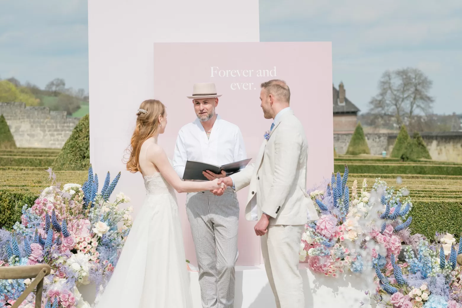 Wedding ceremony backdrop floral arrangement with Delphinium, Clematis Amazing®