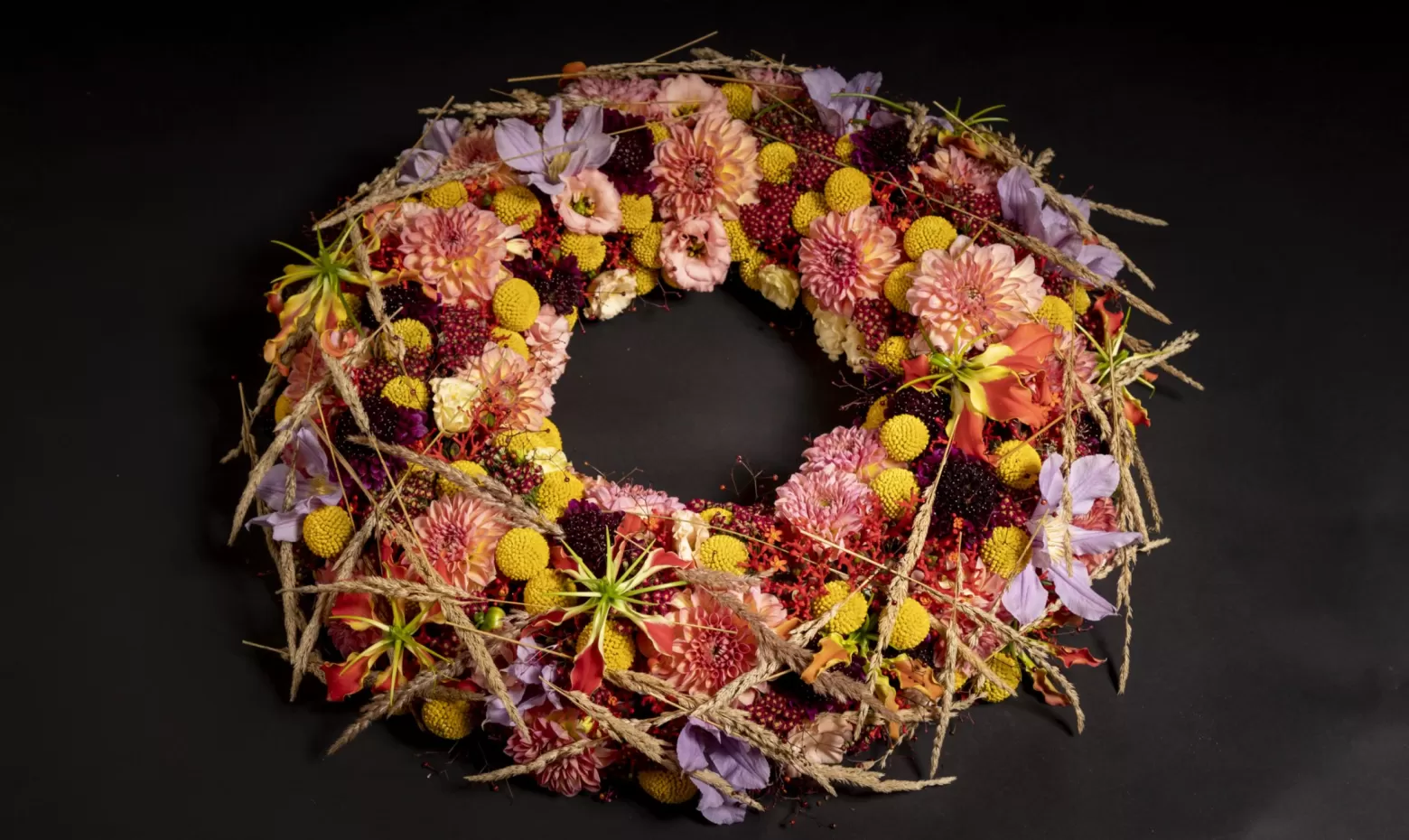 Trauerkranz mit Craspedia, Gloriosa, Jatropha, Clematis, Achillea und Scabiosa